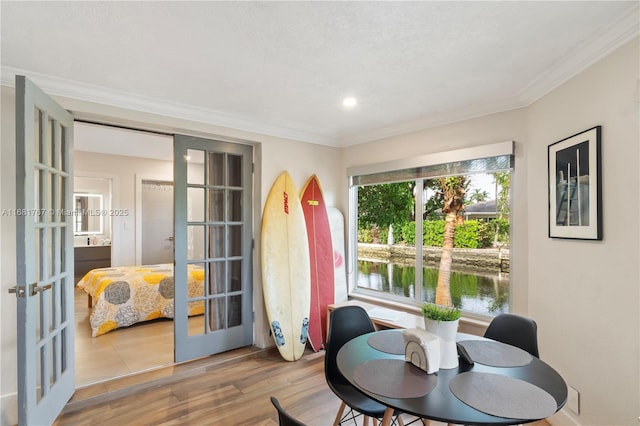 sunroom / solarium featuring a water view and french doors