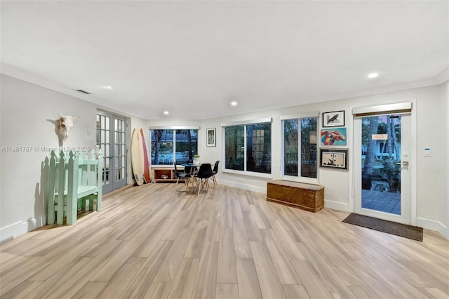 interior space with light wood-style floors, baseboards, crown molding, and recessed lighting