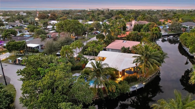 aerial view at dusk featuring a residential view and a water view