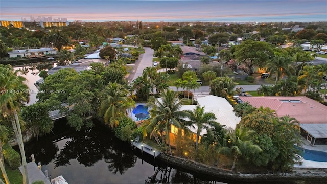 aerial view at dusk featuring a water view