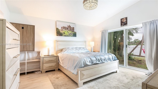 bedroom with access to exterior, lofted ceiling, and light wood-type flooring