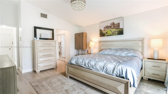 bedroom with light wood-type flooring and vaulted ceiling