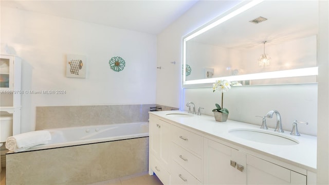 bathroom featuring tiled tub, tile patterned flooring, and vanity