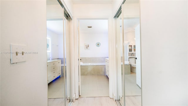 hallway featuring sink and light tile patterned floors