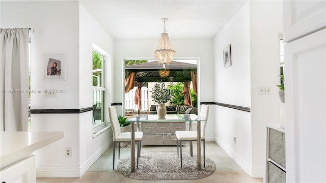 tiled dining room with a chandelier