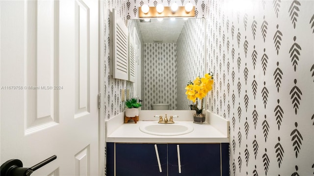 bathroom featuring a shower with shower curtain, a textured ceiling, vanity, and toilet