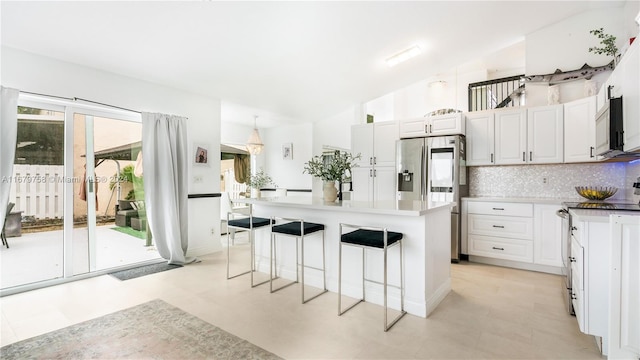 kitchen with white cabinetry, lofted ceiling, a healthy amount of sunlight, and appliances with stainless steel finishes