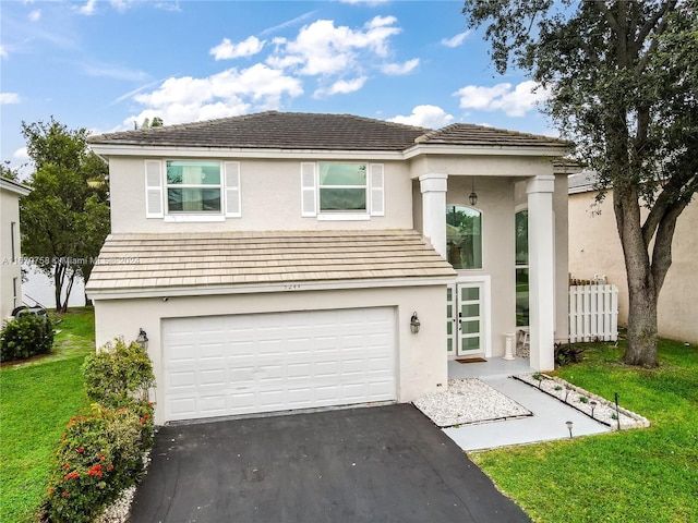 view of property featuring a garage and a front yard