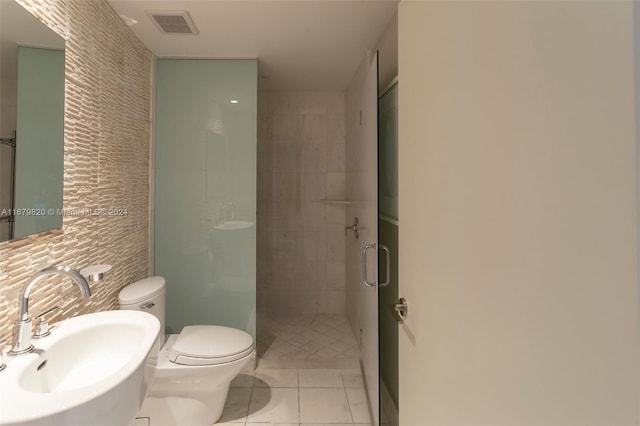 bathroom with toilet, tile walls, sink, and an enclosed shower