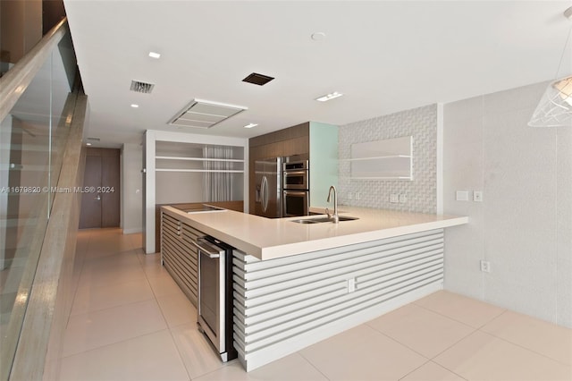 kitchen featuring kitchen peninsula, wine cooler, light tile patterned floors, appliances with stainless steel finishes, and sink