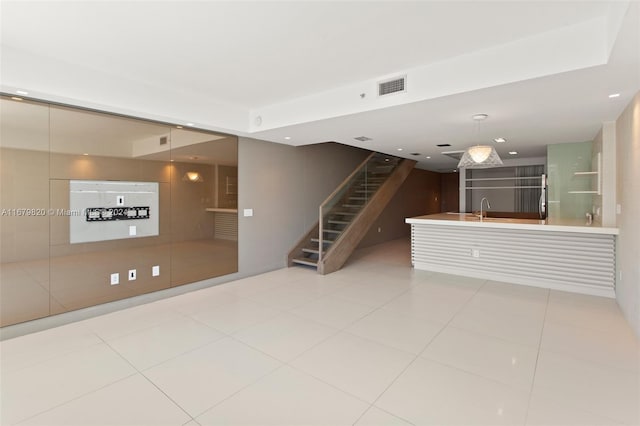 unfurnished living room with sink and light tile patterned flooring