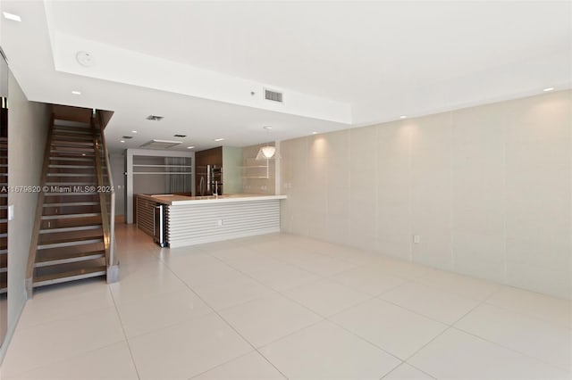 tiled spare room featuring tile walls