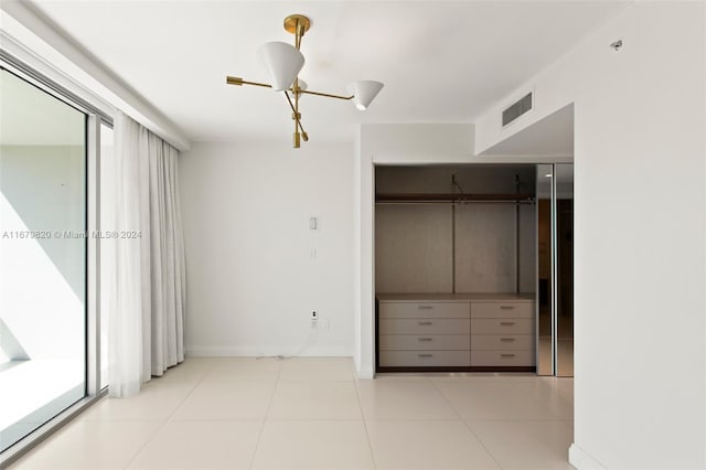 unfurnished bedroom with light tile patterned floors, multiple windows, a closet, and ceiling fan