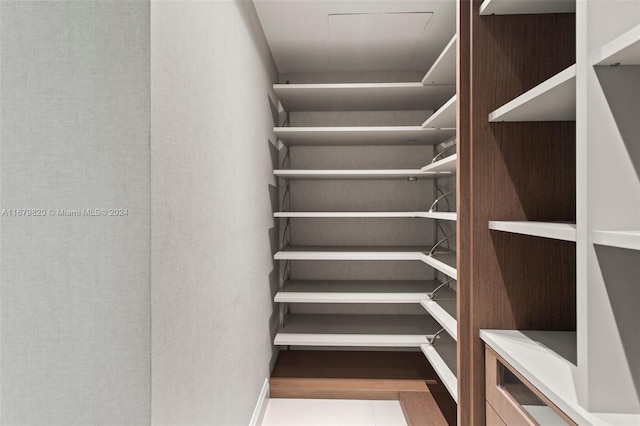 walk in closet with light hardwood / wood-style flooring