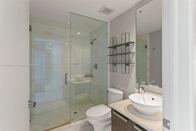 bathroom with vanity, tile patterned flooring, toilet, and an enclosed shower