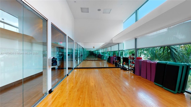 workout area with a towering ceiling and hardwood / wood-style floors