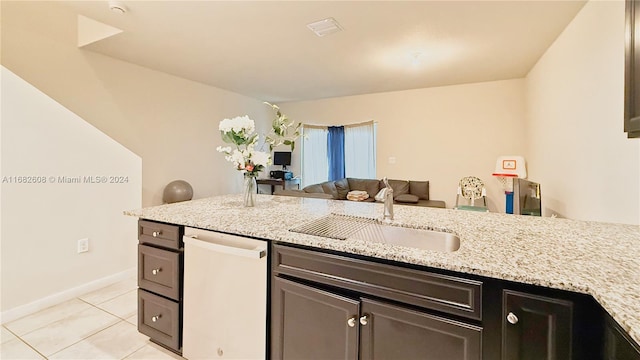 kitchen with light stone countertops, light tile patterned flooring, dishwasher, and sink