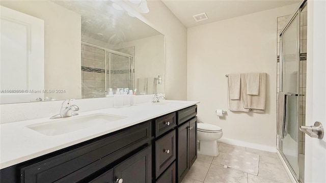 bathroom with a shower with door, vanity, and toilet