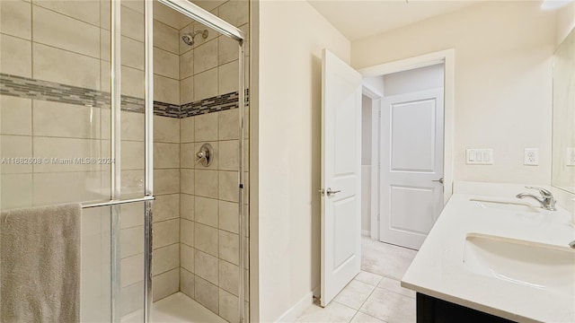 bathroom with tile patterned floors, vanity, and a shower with door