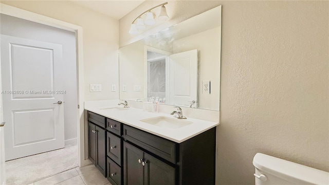 bathroom featuring tile patterned flooring, vanity, and toilet