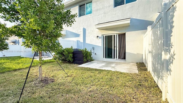 rear view of house featuring a lawn and a patio area