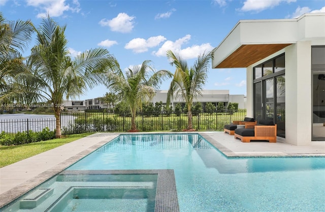 view of swimming pool with a water view, a pool with connected hot tub, and fence