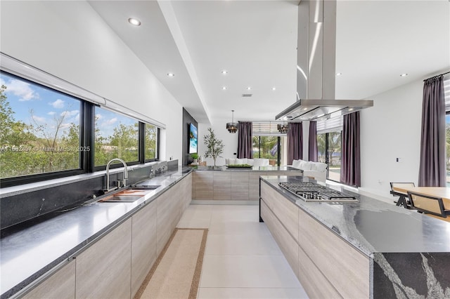 kitchen with a wealth of natural light, stainless steel gas stovetop, light tile patterned flooring, a sink, and modern cabinets