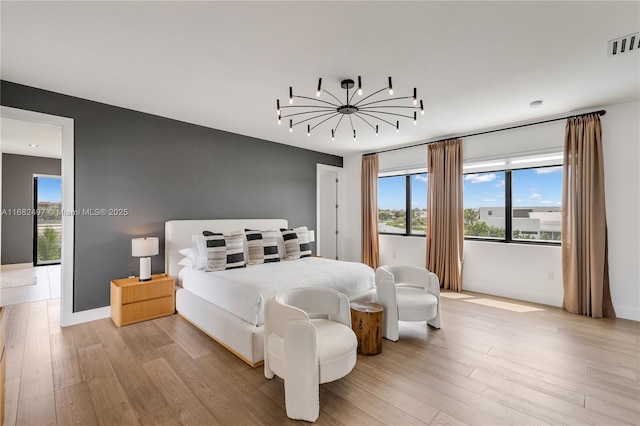 bedroom featuring light wood-type flooring, baseboards, and visible vents