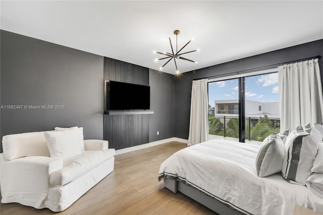 bedroom featuring light wood finished floors, baseboards, and a chandelier