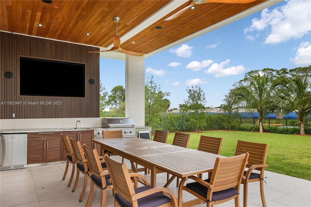 view of patio / terrace with outdoor dining area, an outdoor kitchen, area for grilling, a sink, and fence