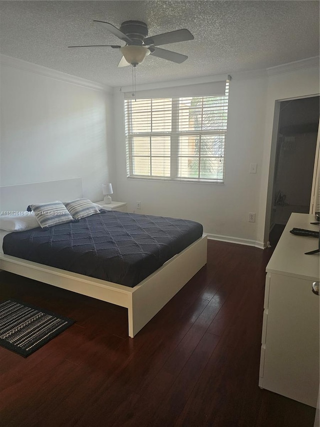 bedroom featuring a textured ceiling, crown molding, dark hardwood / wood-style floors, and ceiling fan