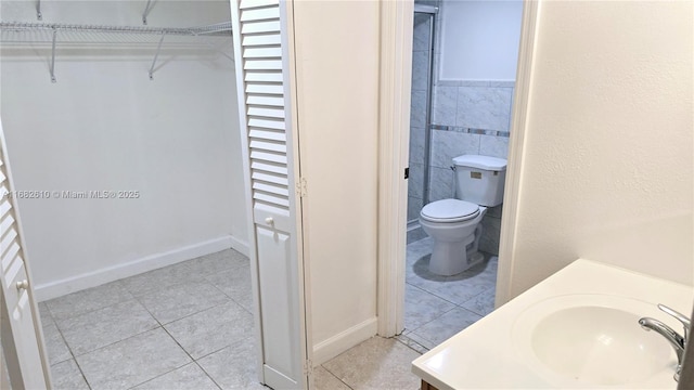 bathroom with tile patterned flooring, vanity, toilet, and tile walls