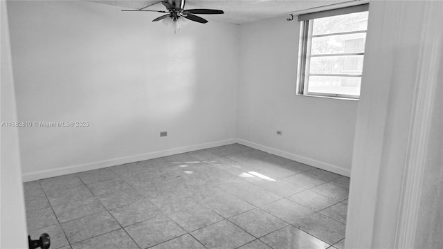 unfurnished room featuring ceiling fan, light tile patterned floors, and a textured ceiling