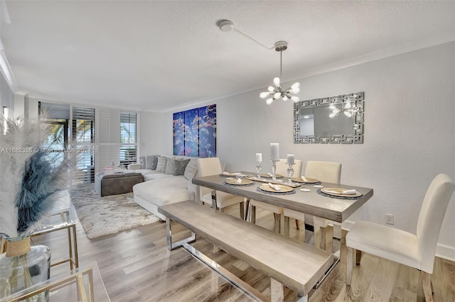 dining area featuring ornamental molding, hardwood / wood-style flooring, and a chandelier