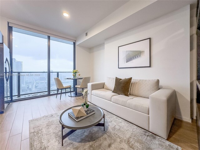 living room featuring wood-type flooring and floor to ceiling windows