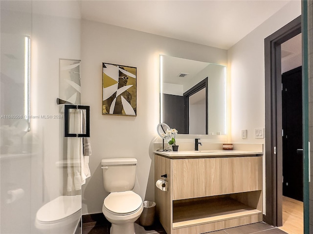 bathroom featuring vanity, toilet, and tile patterned floors