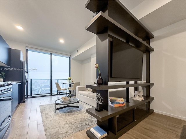 living room featuring a wall of windows and light hardwood / wood-style floors