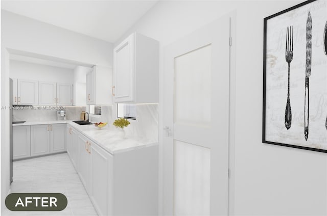 kitchen with decorative backsplash, light stone counters, white cabinetry, and sink