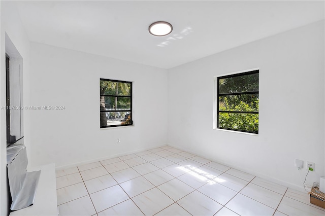 tiled empty room featuring plenty of natural light