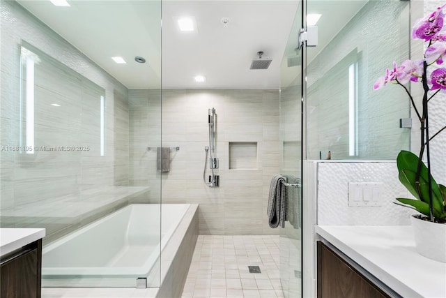 bathroom with tile walls, a washtub, tiled shower, and vanity