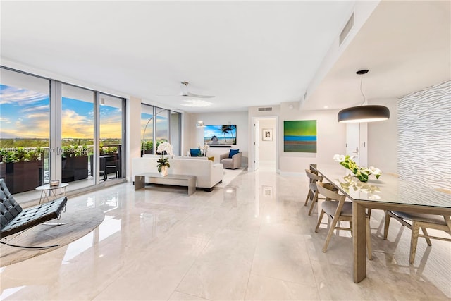 living area featuring marble finish floor, a ceiling fan, visible vents, and floor to ceiling windows