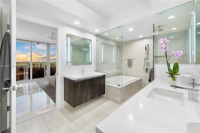 ensuite bathroom featuring a shower with door, a sink, tile walls, and double vanity