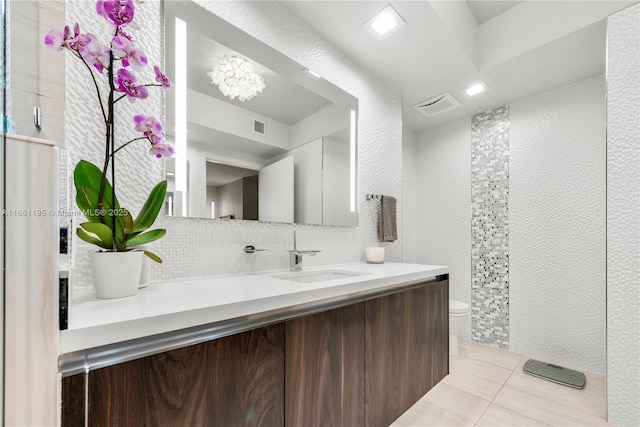 full bathroom with tile walls, visible vents, toilet, vanity, and tile patterned floors