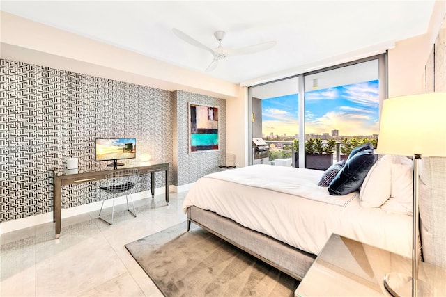 bedroom with access to exterior, a ceiling fan, baseboards, and a wall of windows