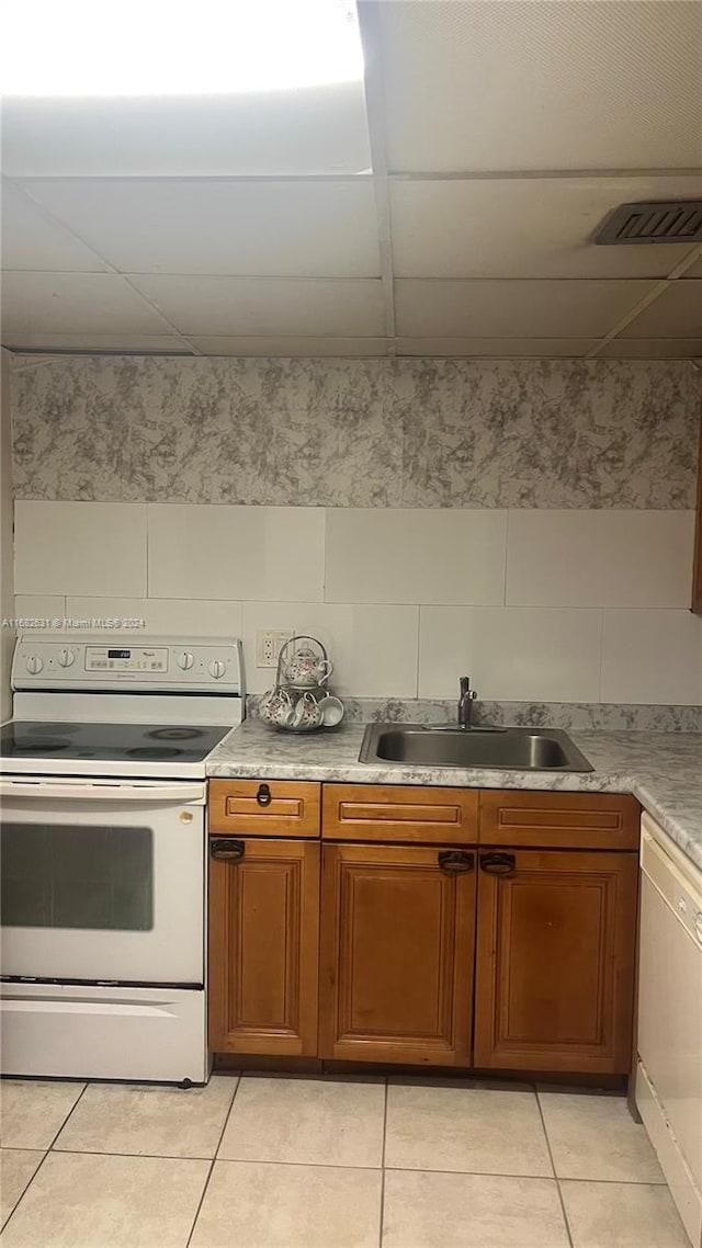 kitchen featuring white appliances, light tile patterned flooring, and sink