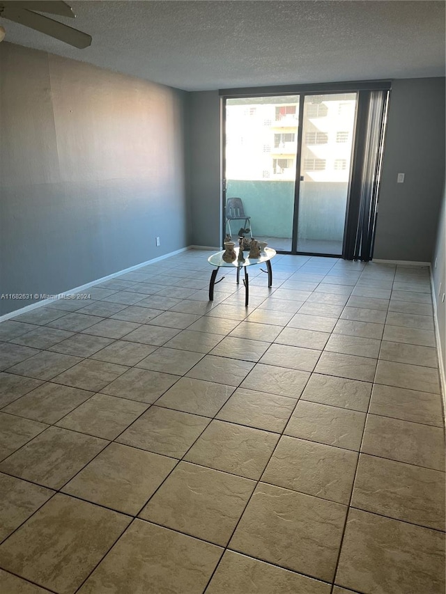 spare room featuring a textured ceiling and light tile patterned floors