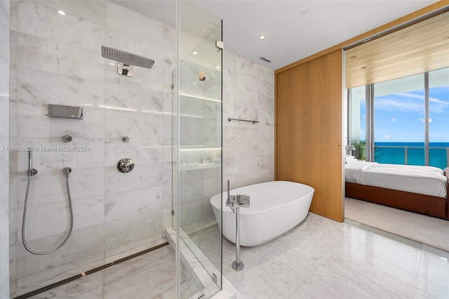 bathroom with shower with separate bathtub and a water view