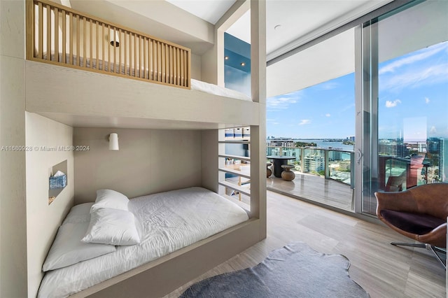 bedroom with access to outside, multiple windows, hardwood / wood-style floors, and expansive windows