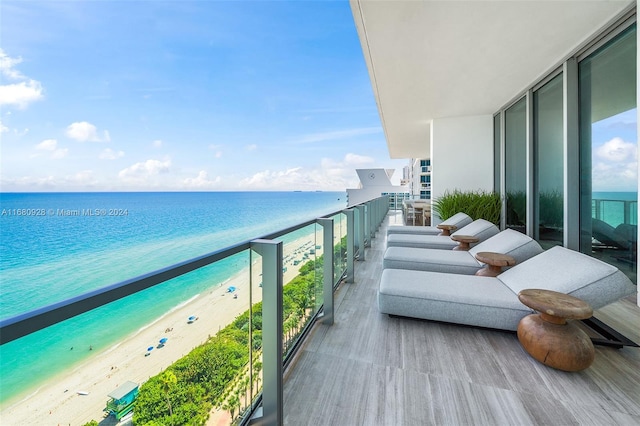 balcony featuring a water view and a view of the beach