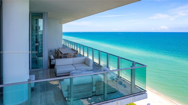 balcony featuring a water view and a beach view